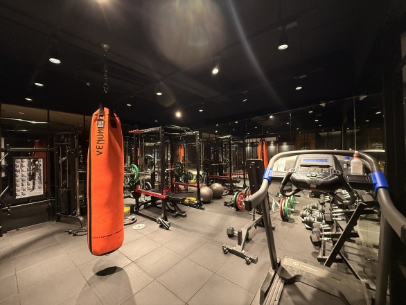 The office gym, with a punching bag, squat racks and a treadmill